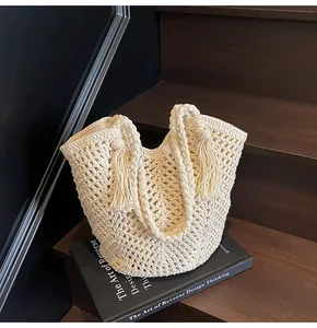 Detailed close-up of cream handmade crochet tote bag featuring hollow mesh and fringe decor