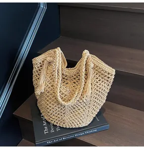 Macro detail of hand-woven straw tote bag with crochet hollow pattern and stylish tassels