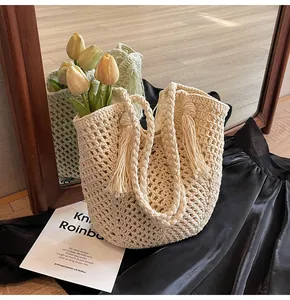 Close-up of beige woven cotton tote bag featuring delicate mesh knit and tassel detail