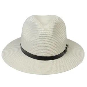 Détail du tressage de paille fine et ceinture en cuir noir sur un chapeau Panama crème