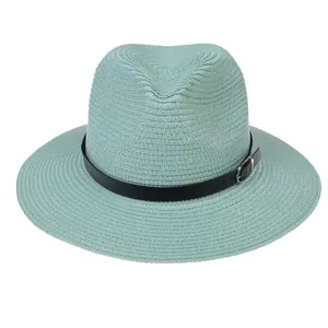 Détail d'un chapeau Panama vert menthe avec texture tissée et bande en cuir noir à boucle