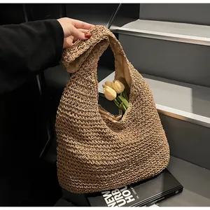 Close-up of khaki straw woven tote bag with natural texture and tulip decoration