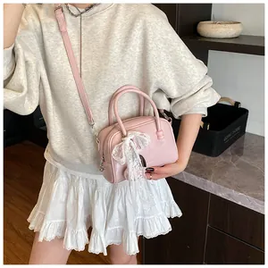 Chic pink bowling handbag for women featuring a sweet white lace bow and versatile crossbody strap.