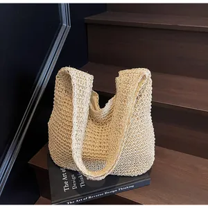 Detail shot of beige woven straw tote bag texture placed on a dark wooden step