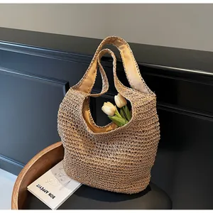 Detail of natural woven straw tote bag with intricate hollow patterns and soft inner lining