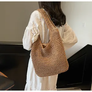Detailed texture of brown straw woven tote bag featuring hollow weave and fabric lining