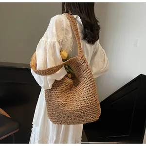 Close-up of a woven straw tote bag with natural texture, styled with a white dress