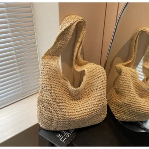 Detailed close-up of woven straw hobo bag with natural crochet texture and beige fabric lining