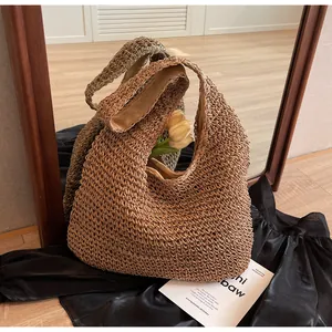Detail shot of a brown woven hollow-out straw hobo bag with a soft fabric inner lining