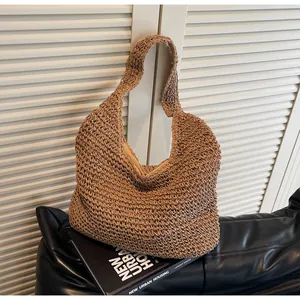Close-up of wavy woven straw texture and wide shoulder strap on beige tote bag