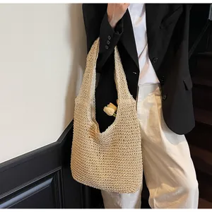 Close-up of beige woven straw tote bag with delicate hollow mesh texture and wide straps