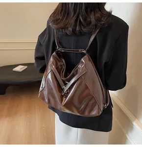 Détail du sac à dos en cuir PU marron brillant avec coutures blanches contrastées au dos