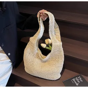 Detail of handwoven cream straw tote bag with elegant scalloped texture and sturdy handles