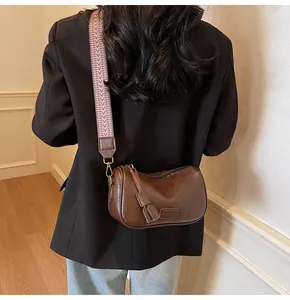 Detailed back view of a dark brown crossbody bag with a wide woven tribal strap