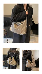 Détail de la texture en cuir verni gris et boucle métallique du sac fourre-tout polyvalent