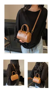 Detail of vintage brown Boston handbag showing crossbody strap and leather texture
