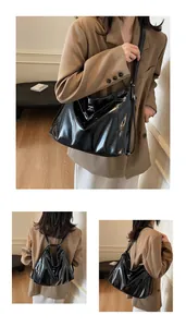 Détail d'un sac bandoulière noir brillant avec surpiqûres blanches et bretelles multiples
