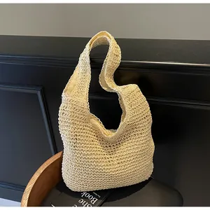 Detailed close-up showing the handmade woven texture of this beige straw hobo shoulder bag