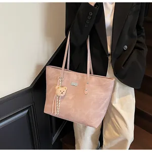 Detailed view of pink marble pattern tote bag with teddy bear charm and silver logo