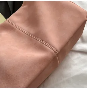 Close-up of precise double-row stitching on high-quality pink suede shoulder bag