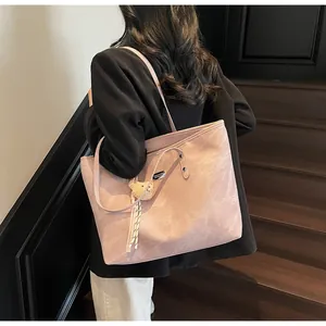 Detailed close-up of pink large capacity tote bag with bear charm and woven cord on shoulder