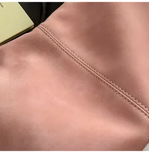 Detail shot of pink suede bag showing premium matte texture and precise stitching