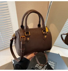 Close-up of brown Boston bag showing vintage leather texture and gold hardware details