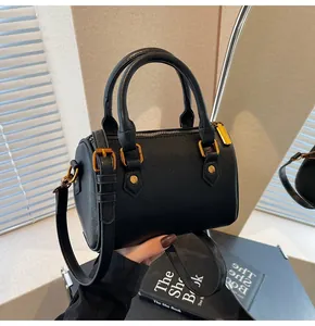 Detailed macro of black Boston bag with lychee texture and golden metal rivets
