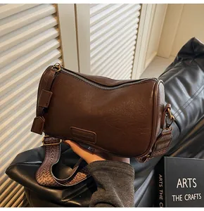 Close-up of retro brown barrel bag showing texture and wide geometric fabric strap