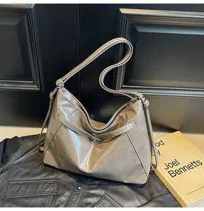 Gros plan du sac cabas en cuir PU taupe avec texture souple sur un fond sombre vintage