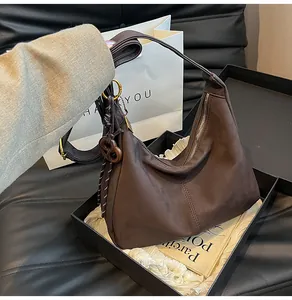 Close-up of vintage dark brown suede handbag with a retro wooden ring ornament detail