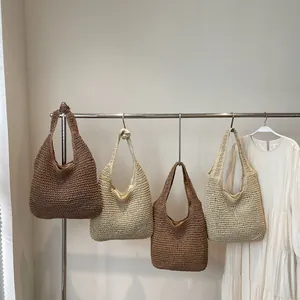 Fashionable woven straw tote bag in brown and beige colors for summer beach vacations