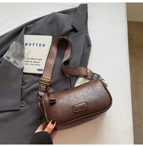 Detail of vintage brown pillow bag with textured leather and patterned wide strap