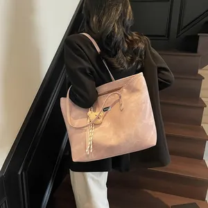 Pink large-capacity tote bag with matte texture and bear charm shown on a shoulder