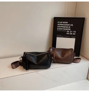 Detail of retro shoulder bags in black and brown with textured PU and wide straps