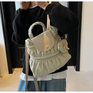Dettaglio dello zaino in nylon pieghettato bianco panna con ciondolo a fiocco