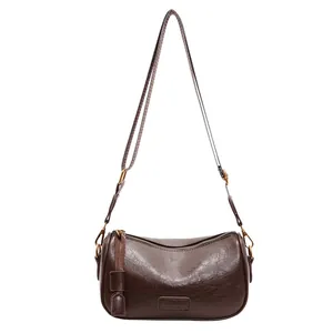 Retro dark brown cylinder crossbody bag in oil-waxed texture leather with adjustable strap