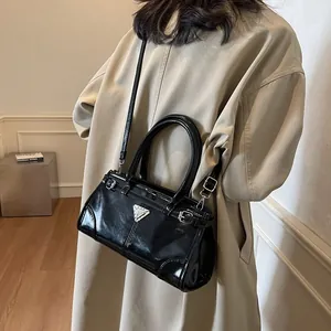 Chic black patent leather crossbody bag with silver triangle plaque and top handles