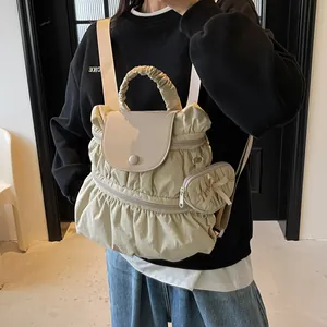 Zaino plissettato in nylon kaki chiaro con patta in pelle grigia e ciondolo con fiocco