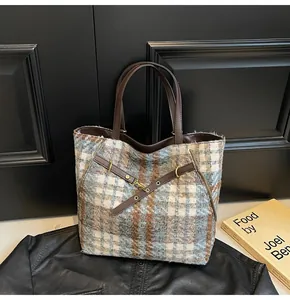 Makro-Detail der gestreiften Tweed-Tasche mit Lederriemen und Vintage-Goldbeschlägen