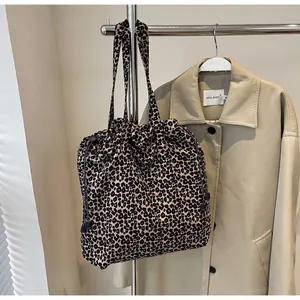 Détail d'un sac cabas léopard avec cordon de serrage réglable et anses doubles en nylon
