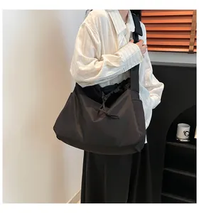 Detailed view of black nylon drawstring tote bag worn on shoulder for style reference