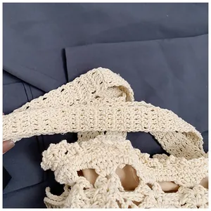 Close-up of beige hand-crocheted bucket bag featuring hollow pattern and fabric lining