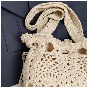 Close-up of hand-woven hollow crochet bucket bag with pearl details and inner lining