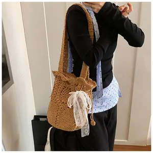 Detail view of woven bucket bag with delicate lace bow and pearl accents on the side