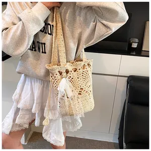 Detail of hand-crocheted bucket bag featuring hollow pattern and lace bow pendant