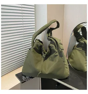Detailed view of the olive green pleated tote bag with drawstring and wide strap