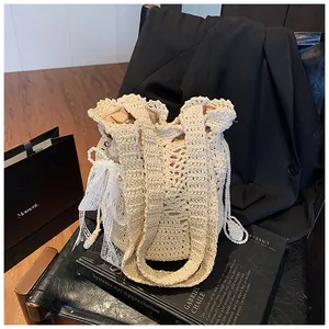 Close-up of beige crochet bucket bag featuring lace bow charms and pearl chain detail
