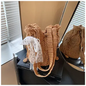 Detail of woven bucket bag featuring white lace bow and elegant pearl charms