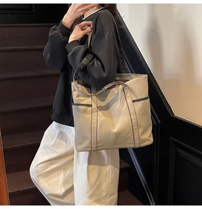 Detailansicht der Khaki Canvas-Tragetasche mit schwarzem Besatz am Modell